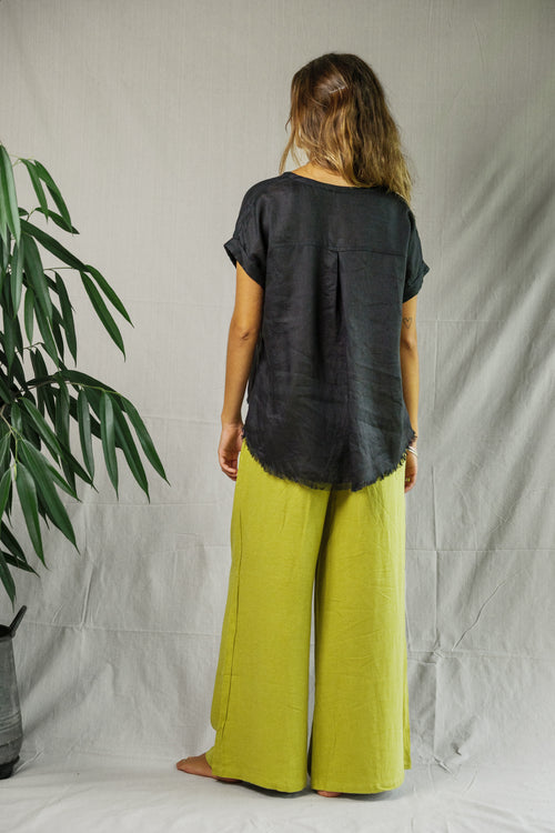 Black linen short-sleeve tee with curved hem worn by woman shown from back.