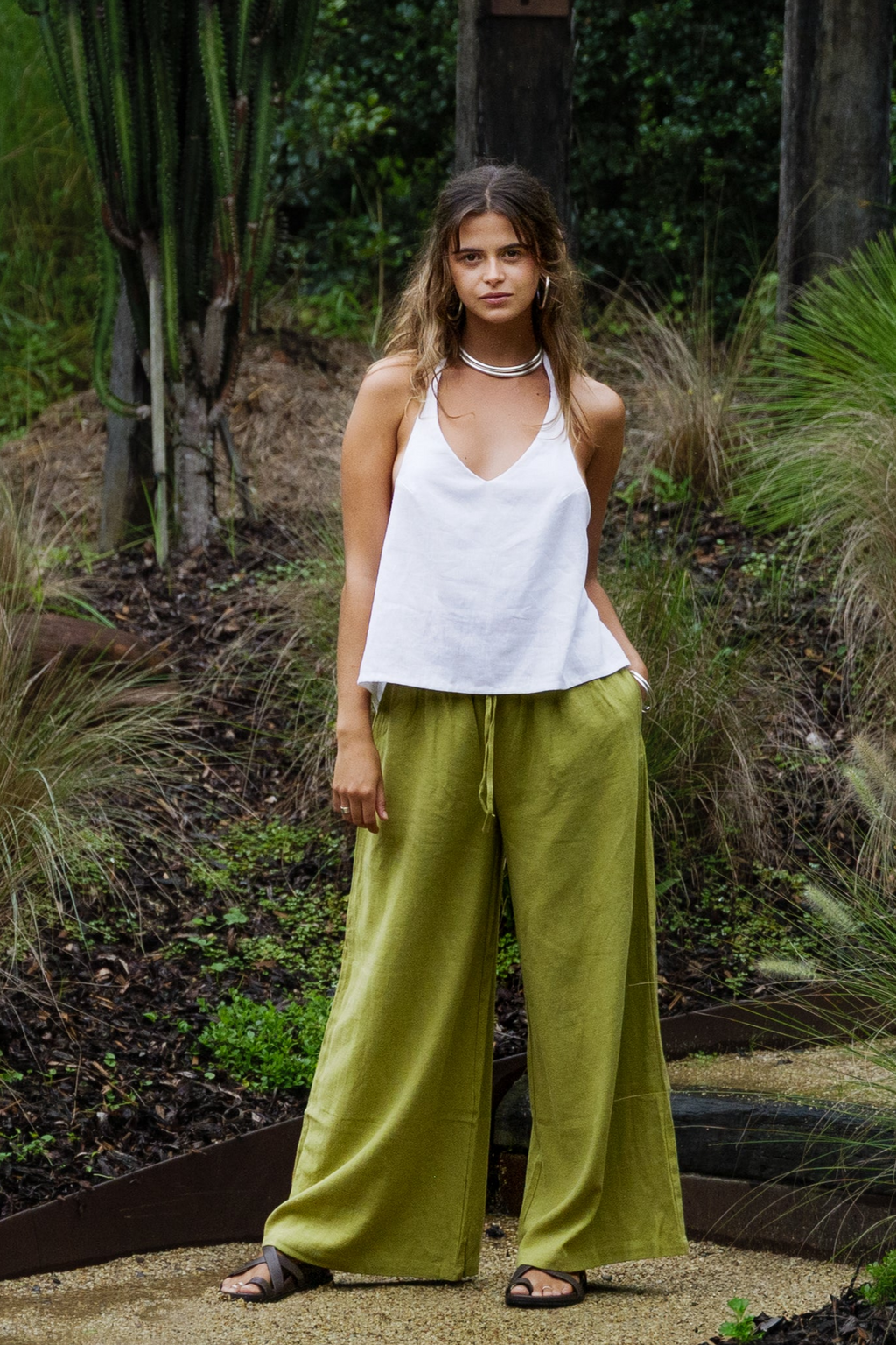 White linen halter top paired with wide-leg olive green pants in an outdoor setting.