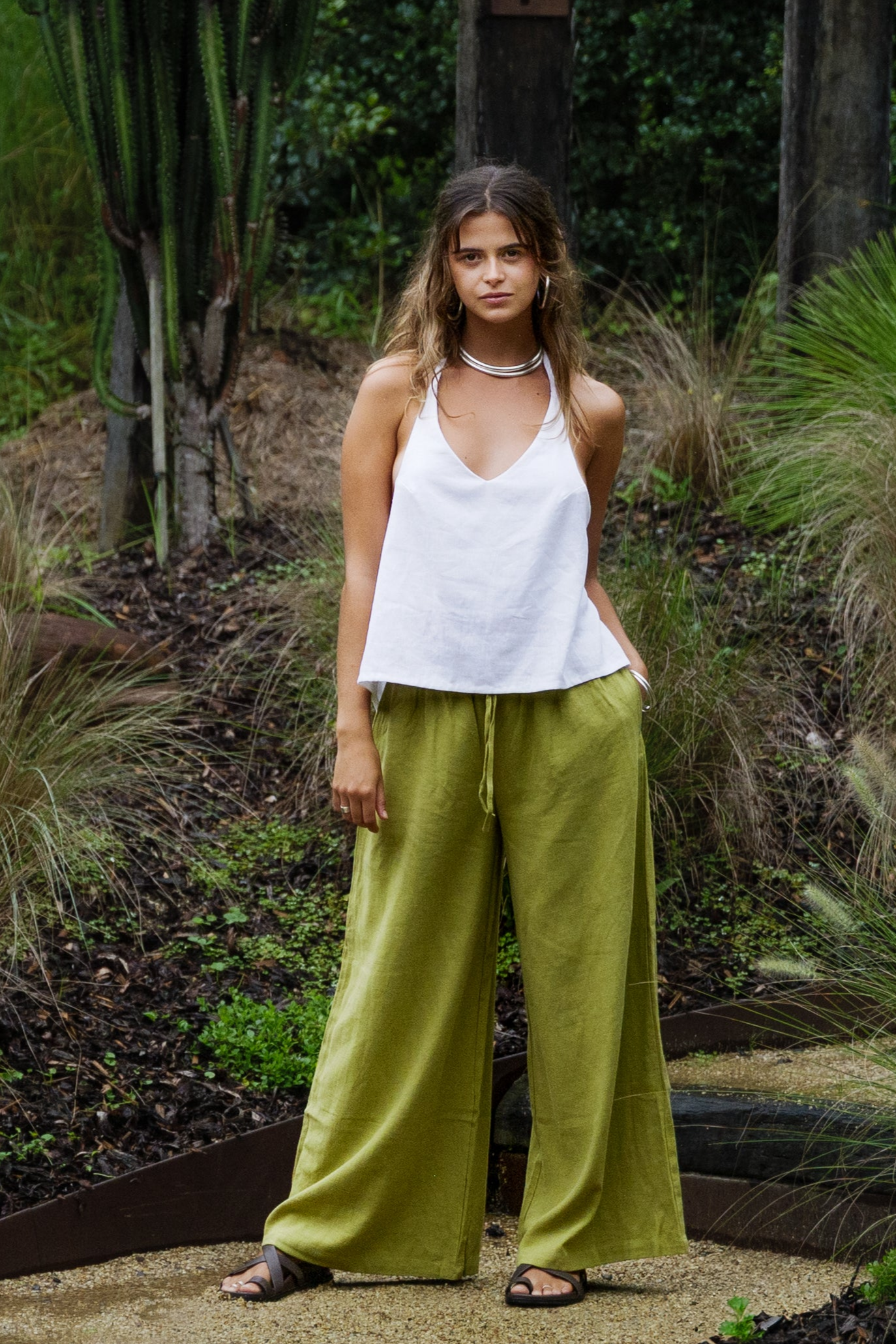 White linen halter top paired with wide-leg olive green pants in an outdoor setting.