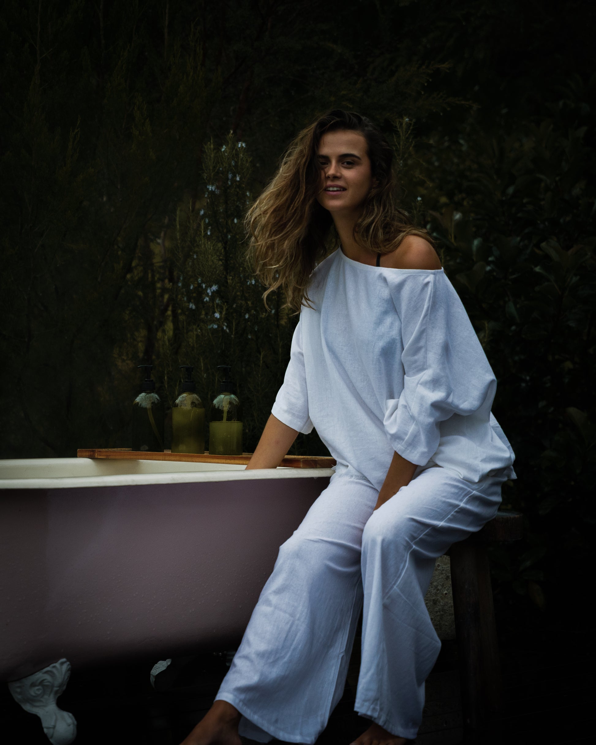 White breathable linen wide-leg pants styled with a loose fit and an elastic waistband.